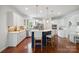 Well-lit kitchen featuring a breakfast bar, white cabinetry, stainless steel appliances, and hardwood floors at 10101 Bayart Way, Huntersville, NC 28078