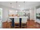 Bright, open kitchen with white cabinets, blue island, stainless steel appliances, and hardwood floors at 10101 Bayart Way, Huntersville, NC 28078