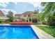 Beautiful pool with a view of the home's exterior, surrounded by vibrant landscaping and well-maintained grounds at 10101 Bayart Way, Huntersville, NC 28078