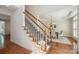 Elegant staircase with wood and white accents, leading to the upper level, adjacent to a formal dining room at 10101 Bayart Way, Huntersville, NC 28078