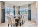 Elegant dining room with a wooden table, neutral chairs, and large windows with modern curtains at 103 White Apple Way, Statesville, NC 28625