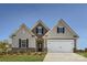 Charming home featuring a mix of stone and siding, complemented by a two-car garage and well-manicured lawn at 103 White Apple Way, Statesville, NC 28625