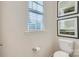 Bright powder room features a toilet, framed artwork, and window with blinds at 103 White Apple Way, Statesville, NC 28625