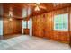 Bedroom with wood-paneled walls, ceiling fan, and bright windows, creating a comfortable living space at 1059 16Th Nw Ave, Hickory, NC 28601