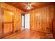 Charming bedroom featuring knotty pine walls, a ceiling fan, and hardwood floors at 1059 16Th Nw Ave, Hickory, NC 28601