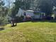 Quaint home with a lush green yard and blooming azaleas, complete with a cozy Adirondack chair at 1059 16Th Nw Ave, Hickory, NC 28601