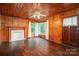 Spacious living room featuring wood paneling, a fireplace, and bright windows with natural light at 1059 16Th Nw Ave, Hickory, NC 28601