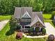 Stunning aerial view of a brick home with lush landscaping and a spacious yard and mature trees at 10716 Persimmon Creek Dr, Mint Hill, NC 28227