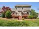 A charming backyard featuring a wooden deck with stairs, lush green grass and mature trees offering a tranquil outdoor space at 10716 Persimmon Creek Dr, Mint Hill, NC 28227