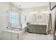Bright bathroom with glass shower, soaking tub, and double vanity featuring modern fixtures at 10716 Persimmon Creek Dr, Mint Hill, NC 28227