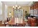 Traditional dining room featuring an elegant chandelier and large window with views to the outdoor landscaping at 10716 Persimmon Creek Dr, Mint Hill, NC 28227