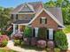 Beautiful two-story brick home with manicured landscaping, black shutters, and a welcoming front porch at 10716 Persimmon Creek Dr, Mint Hill, NC 28227