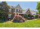 Two-story brick home with lush landscaping, well-manicured lawn, and an inviting covered porch at 10716 Persimmon Creek Dr, Mint Hill, NC 28227