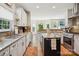 Spacious kitchen featuring white cabinets, a center island, stainless steel appliances and a breakfast area at 10716 Persimmon Creek Dr, Mint Hill, NC 28227