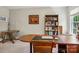 This home office features a spacious wooden desk, custom bookcase, and natural light from a large window at 10716 Persimmon Creek Dr, Mint Hill, NC 28227
