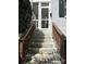 Close-up of the entrance with a brick staircase and brown railing at 119 N Laurel Ave # 1, Charlotte, NC 28207