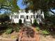 Charming white brick home featuring a grand brick staircase and lush landscaping at 119 N Laurel Ave # 1, Charlotte, NC 28207