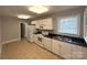 Functional kitchen featuring white appliances, cabinets, and tile flooring at 119 N Laurel Ave # 1, Charlotte, NC 28207