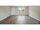 Living room featuring modern gray flooring and two windows with a scenic view at 125 Rocky Pt, Cleveland, NC 27013