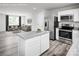 Kitchen showcasing stainless steel appliances, white cabinets, granite counters, and an open view to the living room at 128 Millstream Dr, China Grove, NC 28023