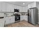 Bright kitchen featuring white cabinets, stainless steel appliances, and granite countertops at 1306 Klondale Ave, Kannapolis, NC 28081
