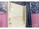 View of bathtub with a shower and floral wallpaper and purple trim on walls at 1467 Alexander Rd, Rock Hill, SC 29732