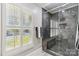 Modern walk-in shower featuring dark tiling with glass enclosure and window at 1467 Alexander Rd, Rock Hill, SC 29732