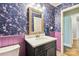 Charming bathroom with floral wallpaper, purple trim, vanity, and an elegantly framed mirror at 1467 Alexander Rd, Rock Hill, SC 29732