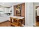 Charming kitchen featuring a decorative brick accent wall, workspace table, and white cabinetry at 1467 Alexander Rd, Rock Hill, SC 29732