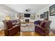 Spacious living room features hardwood floors, comfortable seating, a fireplace, and custom built-in shelving at 1467 Alexander Rd, Rock Hill, SC 29732