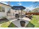 Cozy patio area with a dark patio umbrella, an outdoor dining table, grill and a fire pit, ideal for gatherings and barbecues at 1467 Alexander Rd, Rock Hill, SC 29732