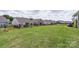 Large, lush backyard with black fencing and a view of surrounding neighborhood homes at 167 White Apple Way, Statesville, NC 28625
