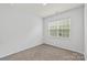 Small, carpeted bedroom featuring a window, neutral paint, and base trim at 167 White Apple Way, Statesville, NC 28625