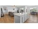 Open-concept living room with wood floors, ceiling fan, and a view into the kitchen at 167 White Apple Way, Statesville, NC 28625