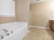 Bright bathroom featuring a soaking tub under a window and a separate shower at 208 Fielding St, Mount Holly, NC 28120