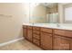 Bathroom features double sink vanity with wooden cabinets and tiled floors at 208 Fielding St, Mount Holly, NC 28120