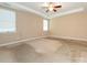 Spacious bedroom with carpet, ceiling fan, and natural light from the windows at 208 Fielding St, Mount Holly, NC 28120