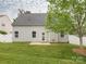 Exterior view of a home showing a well-maintained backyard, patio, and neutral siding at 208 Fielding St, Mount Holly, NC 28120