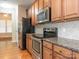 Well-equipped kitchen with stainless steel appliances, granite counters, and wooden cabinetry at 208 Fielding St, Mount Holly, NC 28120
