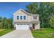 Two story home with beige siding, attached garage, and well-manicured lawn at 2107 Columbidae Ln, Gastonia, NC 28052