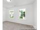 Neutral-toned bedroom with carpeting and two windows offering views of the neighborhood at 2309 Bulwarks Ct # 4P, Albemarle, NC 28001