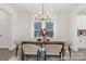 Bright dining room with a modern chandelier, white curtains, and seating for six around a wooden table at 2309 Bulwarks Ct # 4P, Albemarle, NC 28001