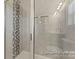 Tiled shower with glass door and decorative accent tile stripe at 2309 Bulwarks Ct # 4P, Albemarle, NC 28001