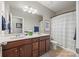 Well-lit bathroom with double vanity, modern fixtures, and a shower-tub combination with striped curtain at 2322 Morrison Rd, York, SC 29745