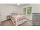 Bright bedroom featuring a metal frame bed, ceiling fan, and a large window at 2514 King Arthur Dr, Monroe, NC 28110