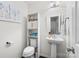 Bright bathroom features a pedestal sink and a white storage cabinet at 2739 Golden Rose Ln, Charlotte, NC 28216