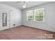 Bedroom showcasing carpeted floors, bright windows, ceiling fan, and a door-mounted mirror at 3015 North Center Nw St, Hickory, NC 28601