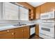 A kitchen featuring wood cabinets, a double basin sink, and white appliances beneath a bright window at 3015 North Center Nw St, Hickory, NC 28601