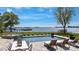 Inviting pool area with lounge chairs, dining set, lush lawn, and serene lake views at 356 Yacht Rd, Mooresville, NC 28117