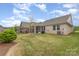 A view of the brick home exterior showcasing the backyard with a patio and well-kept landscaping at 3618 Marchers Trace Dr, Mint Hill, NC 28227